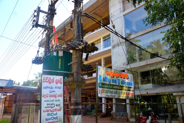Professional Sri Lankan businessman in navy suit smiling confidently in modern office